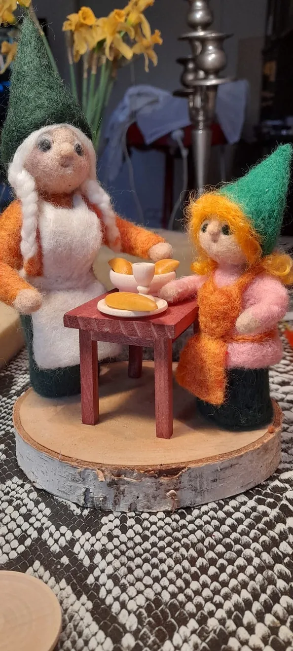 Zwei Wichtelfiguren bei einer gemeinsamen Mahlzeit.
